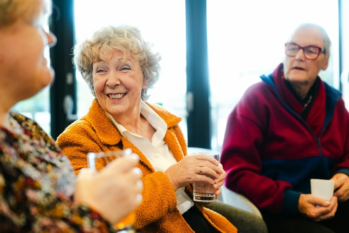 Three older neighbours talking and smiling together