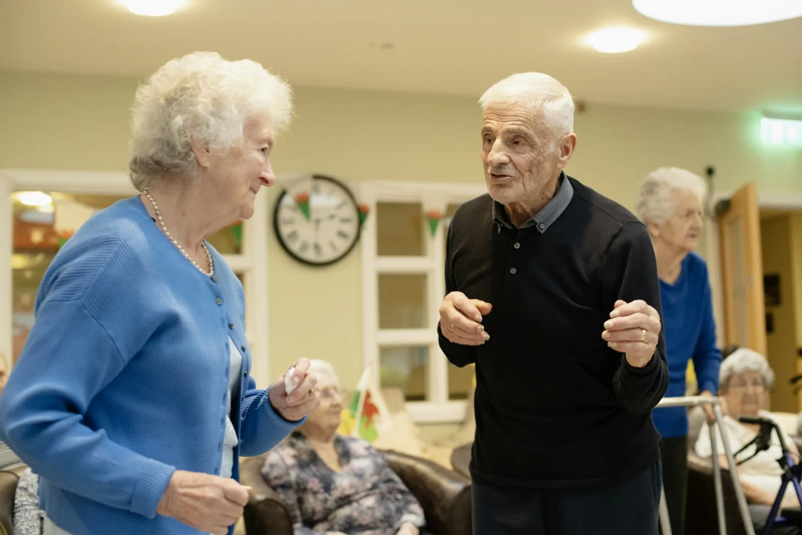Older neighbours talking and laughing together at a community gathering